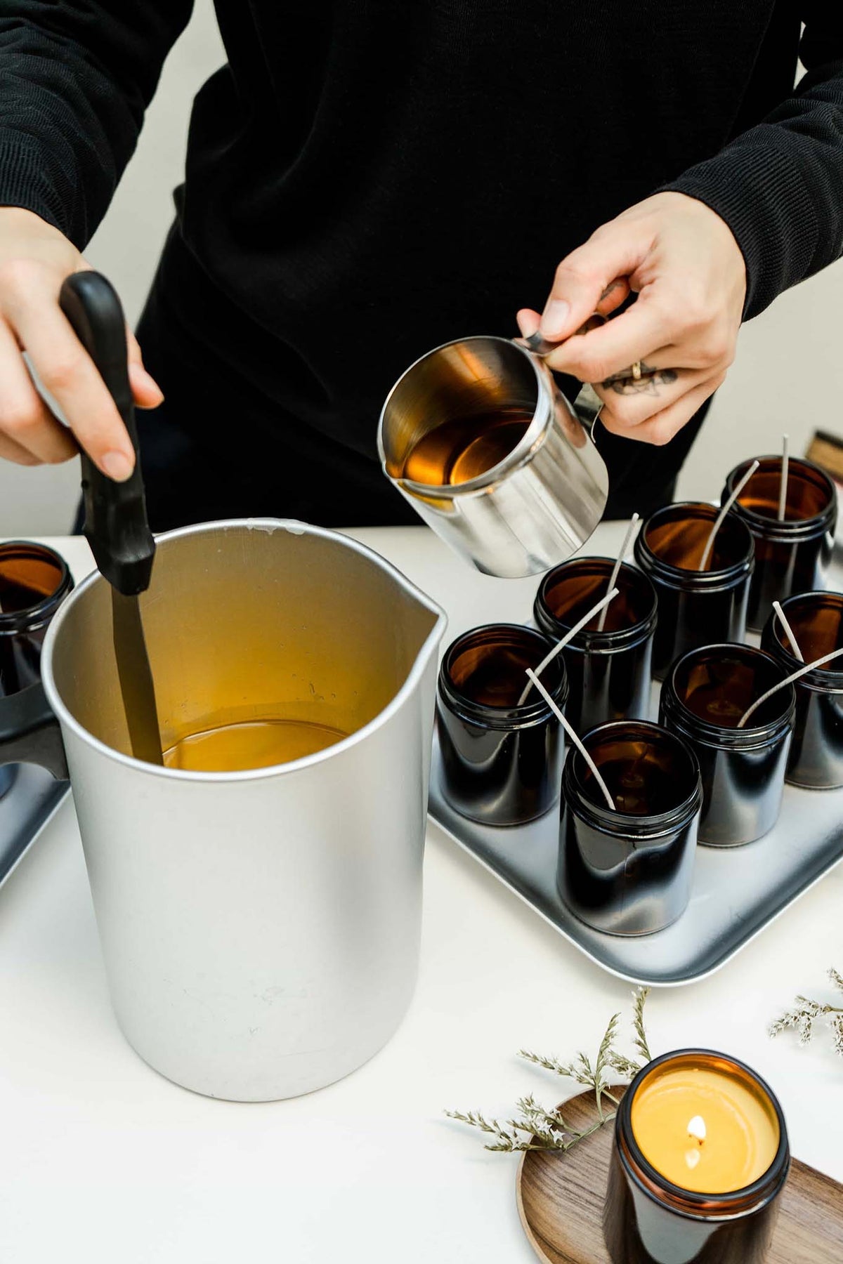 Pouring melted soy wax into candle jars