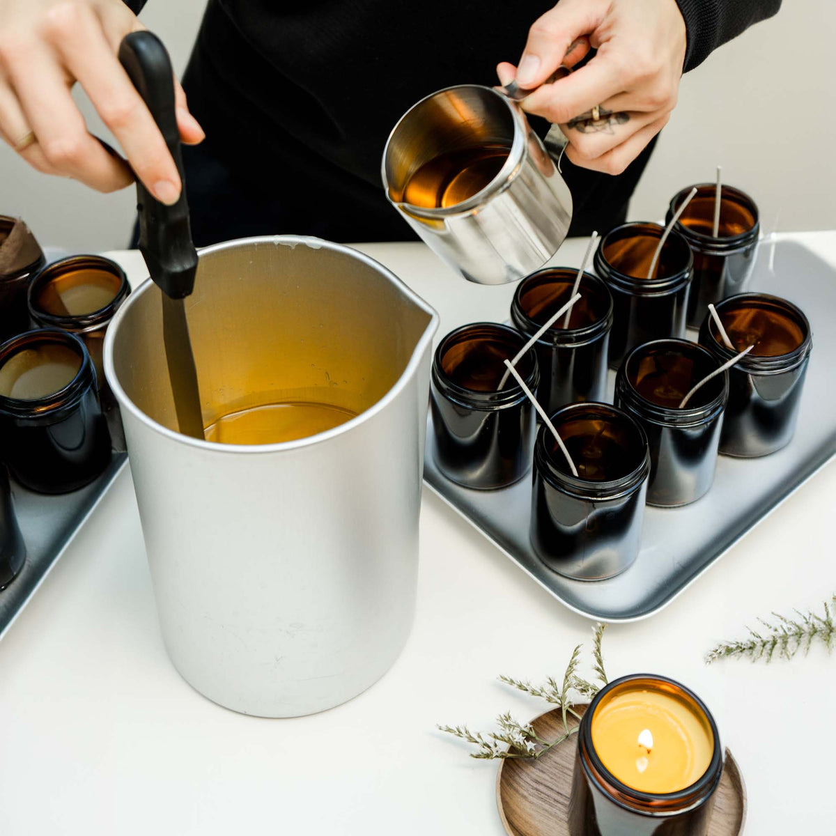 Pouring candle wax into jars for an autumn candle range