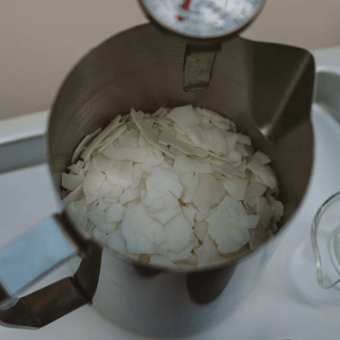 Soy wax flakes melting in a candle wax pouring jug